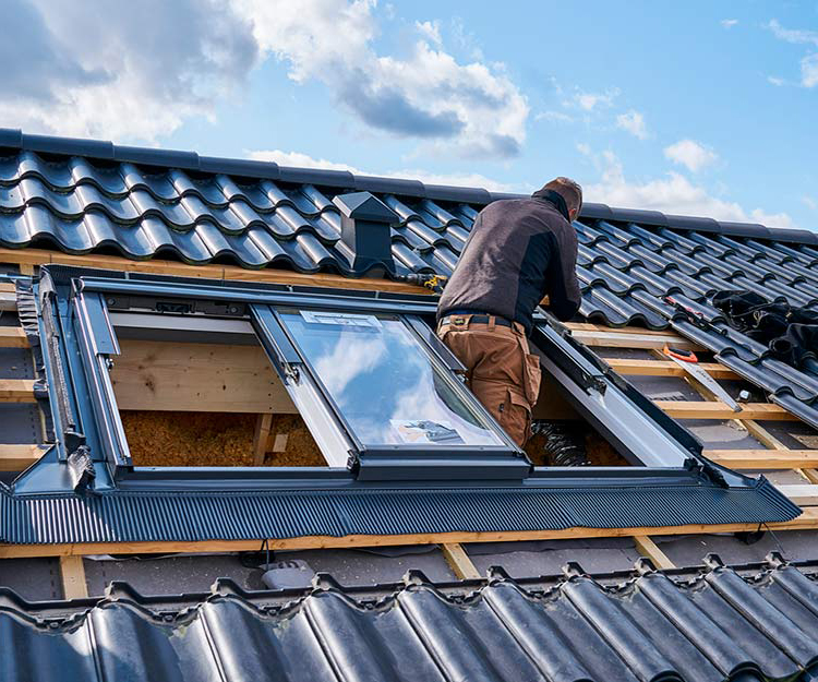Couvreur posant une fenêtre de toit velux près de Bruxelles
